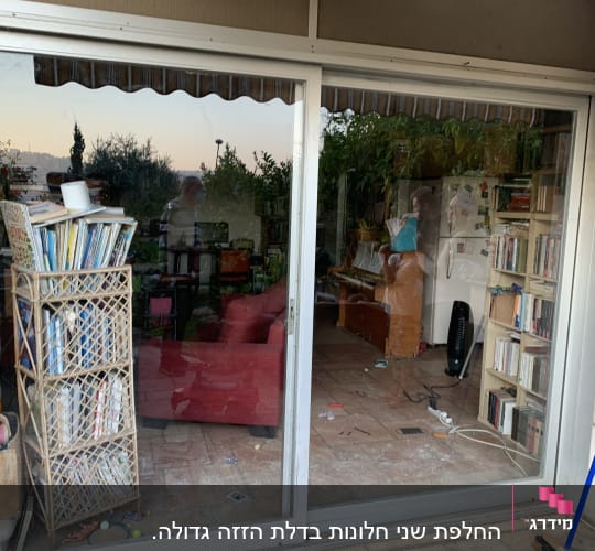 דלת זכוכית גדולה עם השתקפות של פנים הבית